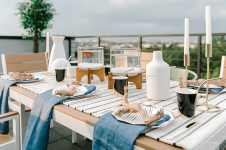 A beautiful dining table is set outdoors with tasteful decor, ready for a gathering with friends and family.の写真素材