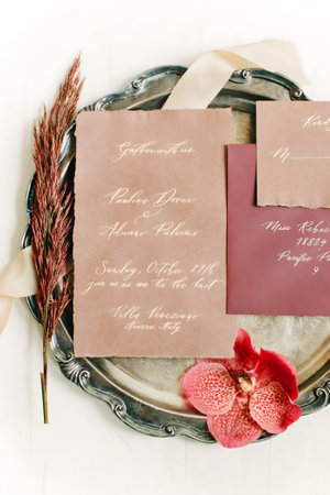 Elegant wedding invitations with floral accents showcased on a decorative tray create a beautiful atmosphere.の写真素材