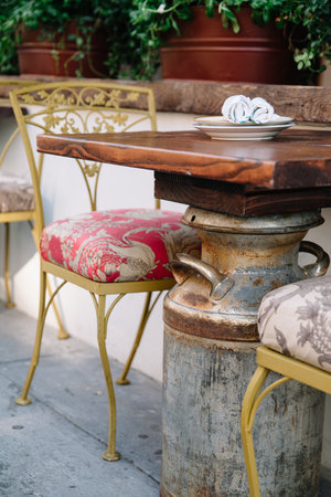 Cozy dining area with a rustic table, colorful chairs, and potted plants for a vibrant feel.の写真素材