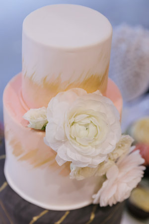 A pastel wedding cake adorned with delicate flowers adds elegance to the celebration.