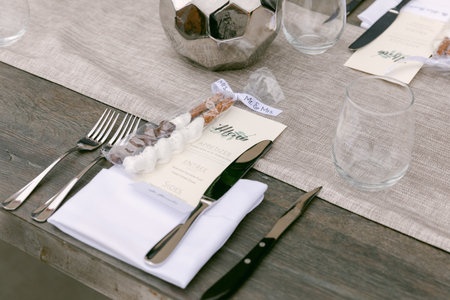 An inviting dining arrangement with elegant silverware, glasses, and personalized menus set for a...