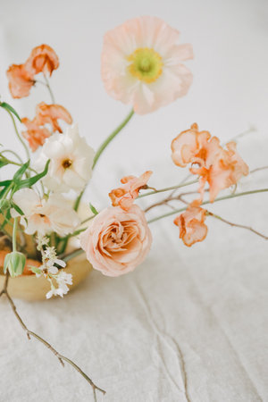 A beautiful display of soft-colored flowers in a small vase highlights their elegance and charm in a simple setting.の写真素材