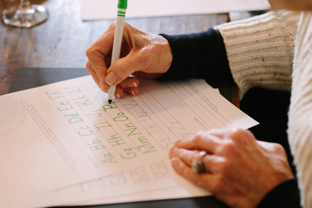 Hands write letters in a warm calligraphy class filled with creativity.の写真素材