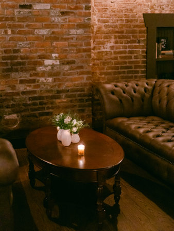 Cozy lounge area with brick walls and comfortable seating during evening hoursの写真素材