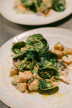 Fresh seafood salad with herbs and new potatoes, artfully presented at a fine dining restaurant.の写真素材