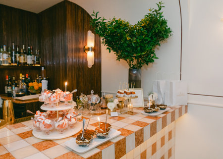 A stunning dessert table features cakes and pastries in a stylishly decorated setting.の写真素材