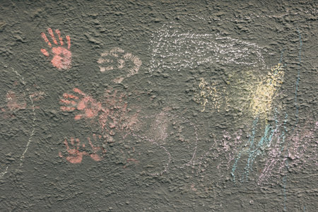 Colorful handprints created with natural pigments decorate an ancient cave wall, showcasing early human creativity.の写真素材