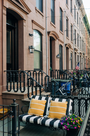 Relaxing patio with striped cushions and blooming flowers on a charming street in a vibrant...