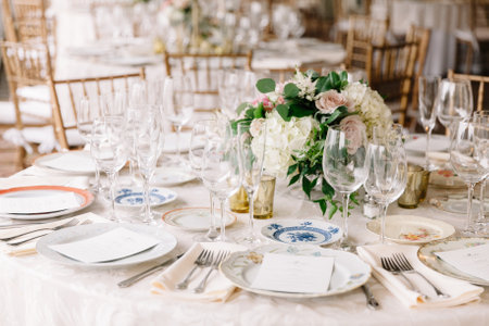 Beautifully arranged dining table featuring fine china, glassware, and a lush floral centerpiece...