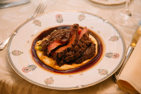 Succulent beef slices atop smooth mashed potatoes, drizzled with savory sauce for an elegant dining experience.の写真素材