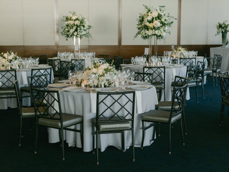 Beautifully arranged tables with floral centerpieces set for a formal gathering in a stylish banquet...