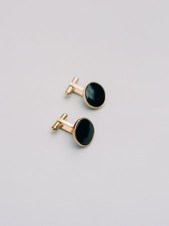 Stylish cufflinks featuring a black design set against a neutral backdrop, perfect for enhancing formal outfits.の写真素材