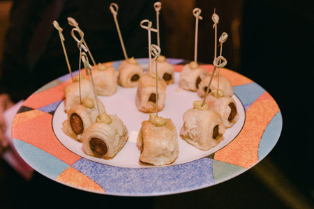 A platter of savory hors d'oeuvres with toothpicks is presented at a social gathering during the...