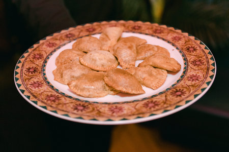Scrumptious empanadas presented on a decorative plate during a joyful celebration with family and...