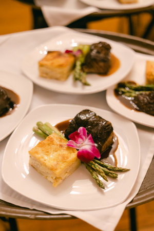 A beautifully arranged dish showcases savory beef, creamy casserole, and crisp asparagus with a...