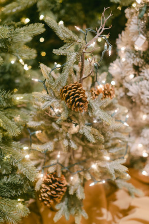 Christmas tree adorned with pine cones and sparkling lights creates a warm holiday atmosphere.の写真素材