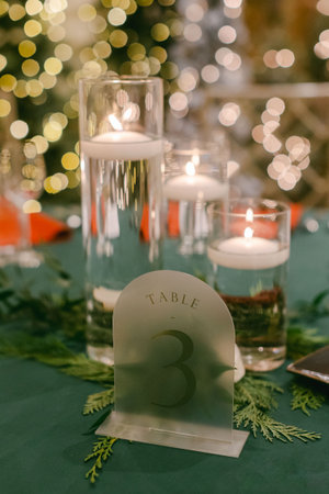 A lovely table with floating candles, glass vases, and bright greenery, ideal for a holiday gathering.の写真素材