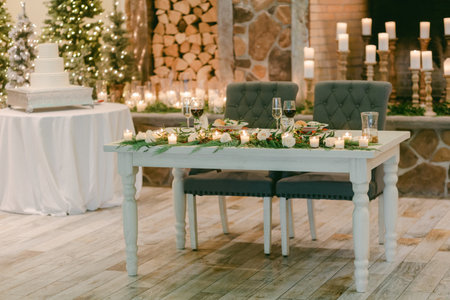 A beautifully arranged dining table with a festive centerpiece, set for a winter celebration with soft lighting.の写真素材