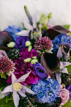 A stunning bouquet composed of rich purple, blue, and green flowers, showcasing textures and vibrant colors.の写真素材
