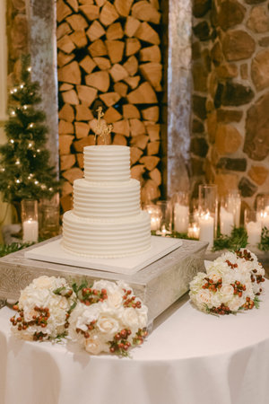 A beautifully designed wedding cake is showcased with flowers and candles, creating a warm, inviting atmosphere.の写真素材