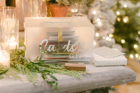 A beautifully arranged card and gift box on a table, surrounded by candles and holiday decor, creates warmth.の写真素材