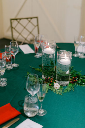An elegant dinner table adorned with candles, festive greenery, and fine tableware, perfect for celebration.の写真素材