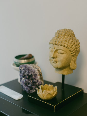 A Buddha statue stands among crystals and a lotus flower, creating a peaceful atmosphere in a modern...