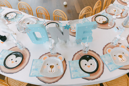 Colorful birthday party table displays animal-themed plates and decorations celebrating a child's...