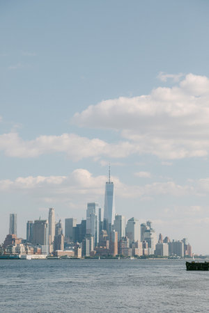 A vibrant urban skyline is visible from the water, featuring skyscrapers and a tall iconic structure...