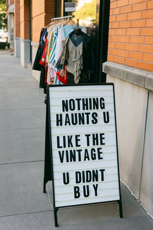 Boutique sign highlights the appeal of vintage clothing, attracting shoppers to explore unique styles.