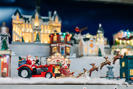 Colorful decorations and miniature buildings create a joyful holiday atmosphere with Santa and his sleigh.の写真素材
