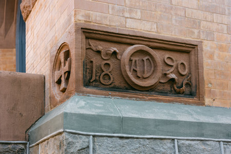 A stone carving from 1890 on a brick building showcases its historical significance and craftsmanship.の写真素材