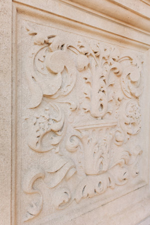 The stone surface features detailed floral patterns, highlighting skilled craftsmanship on a historic structure.の写真素材