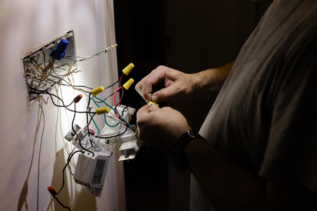 Electrical work at night with focus on wiring and connections in a residential settingの写真素材