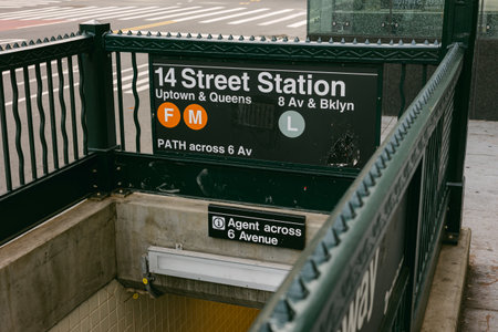 Sign for 14 Street Station in New York City showing subway lines and directions on a busy streetの写真素材