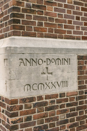 Historic stone carving of Anno Domini from 1928 on brick wall in a charming urban settingの写真素材
