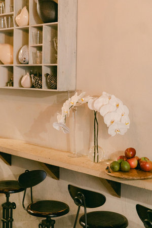 Tastefully designed cafe features white orchids and fresh fruit, creating a welcoming atmosphere for...