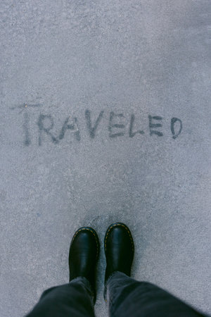 Footwear is positioned on surface holding the word traveled in dust showing recent movement or...