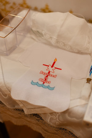 A white cloth with a design for baptism sits on a table in a church setting during a religious ceremony.の写真素材