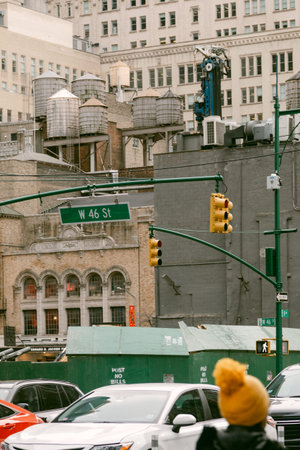 Traffic moves along West 46 Street as a person walks by water towers on building rooftops in New...