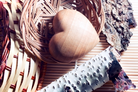 Different kinds of wood   birch, pine, maple, ash, nut  on the bamboo mat  Heart of wood is in a  wicker basket  Two wicker baskets made of vine and willow on the table の写真素材