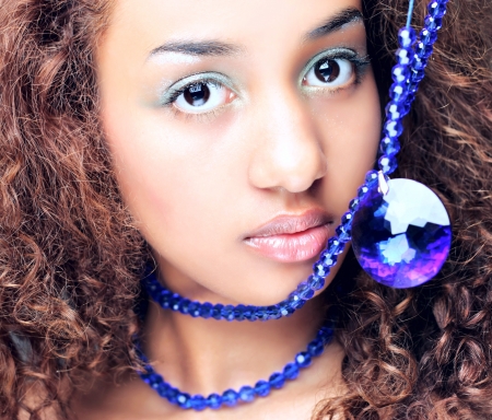Young mulatto woman with a fashionable Afro hairstyle showing a beautiful necklace  の写真素材