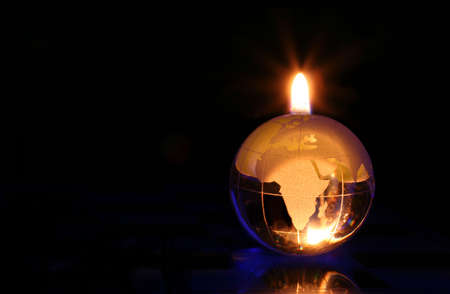 Glowing Glass Globe on Black Background With Flameの写真素材