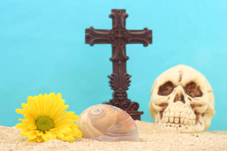 Cross and Skull with Flowers on Sand With Blue Backgroundの写真素材