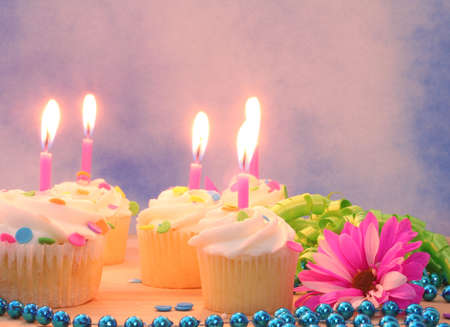 Flowers and Cupcakes with Candles on Blue Sky Backgroundの写真素材