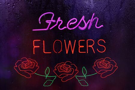 Neon Fresh Flowers Sign in Rainy Window