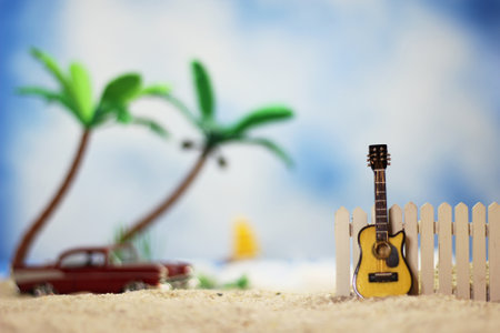 Guitar on Tropical Beach with Vintage Hot Rod in Backgroundの写真素材