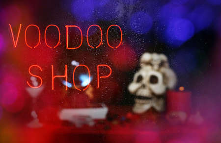 Voodoo Shop Sign in Rainy Window with blurred skull
