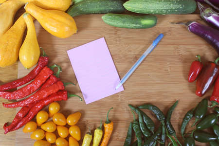 Organic Summer Vegetable Harvest on Table With Note Pape and Penの写真素材
