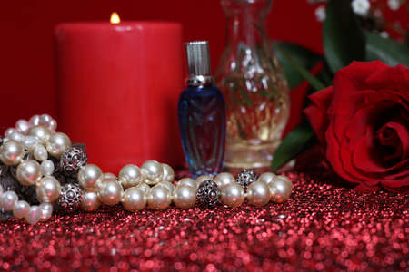 Candle and Red Rose With Perfume on Red Velvet Backgroundの写真素材